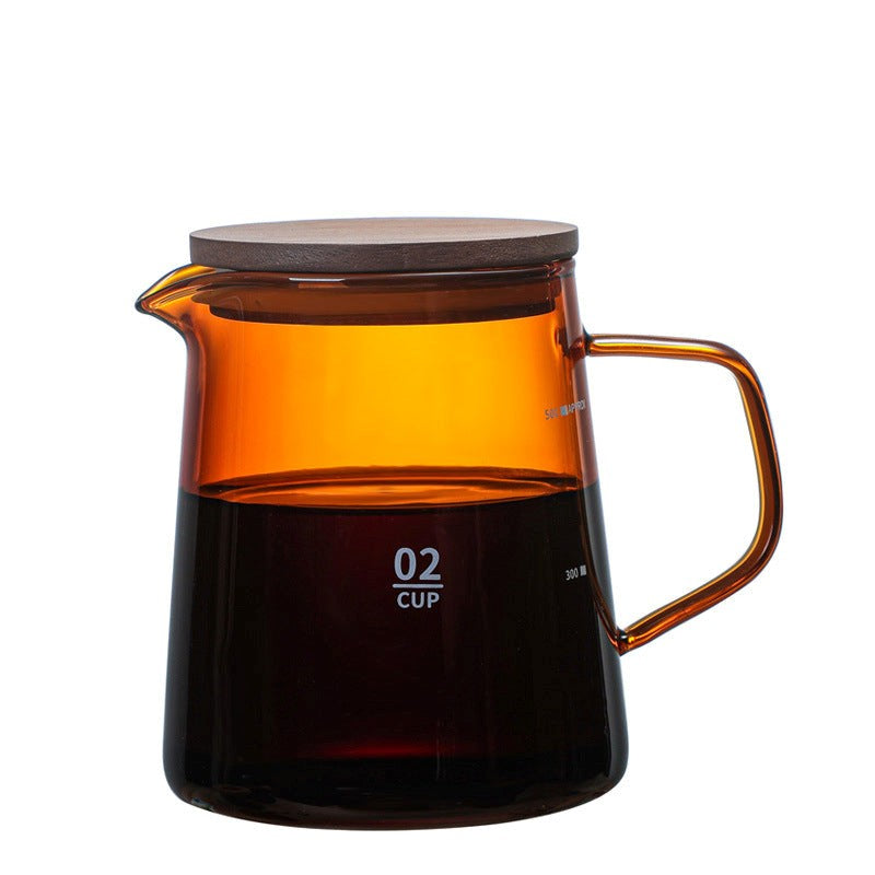 Clear glass coffee maker with amber-colored interior and wooden lid on a white background