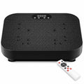 A black vibration plate exercise machine with a textured non-slip surface and digital LED display, accompanied by a white remote control on a clean white background.