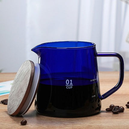 Blue glass measuring cup with wooden lid on a wooden surface with coffee beans.