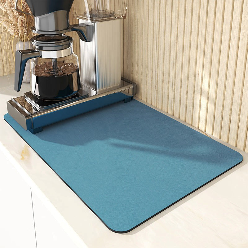Blue mat in front of a coffee maker on a kitchen counter