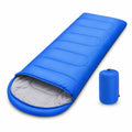 Blue sleeping bag laid flat with an open hood and light grey inner lining, accompanied by a matching blue compression sack standing upright on a white background.