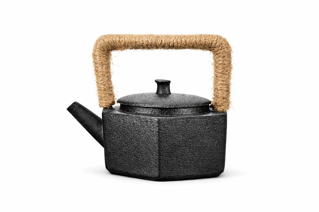 Black teapot with a woven handle on a white background