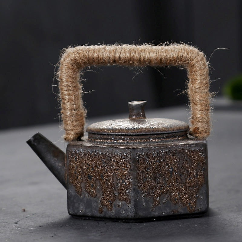 Vintage-style teapot with a textured handle on a dark background