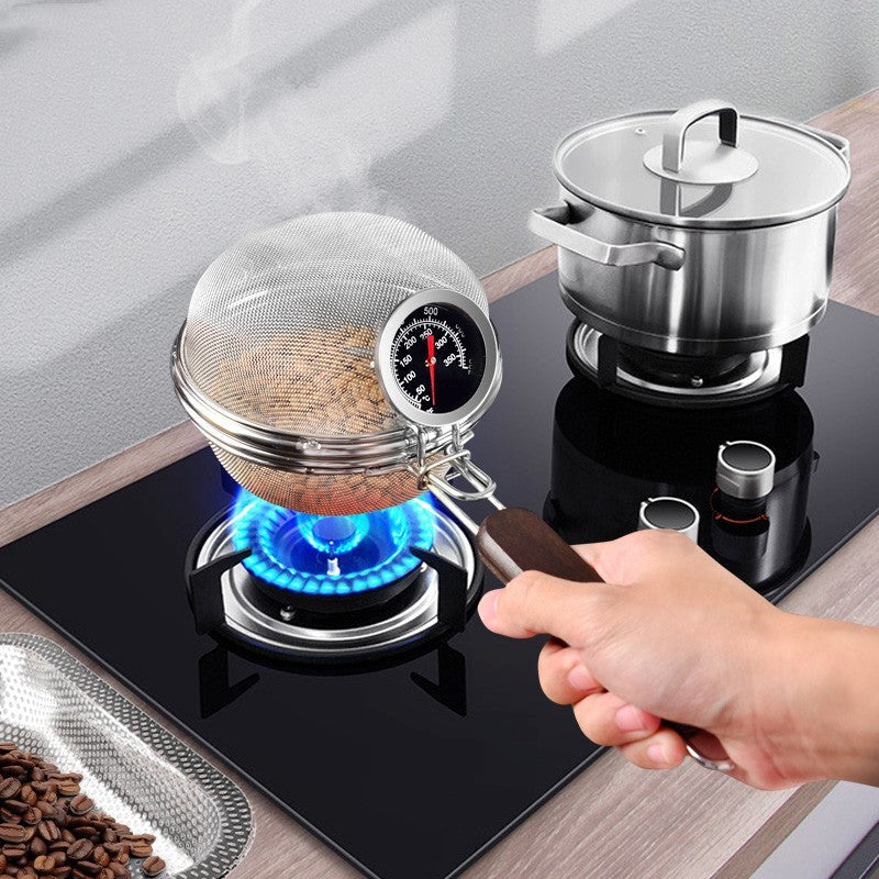 Person using a coffee grinder on a gas stove with coffee beans and a pot in the background.