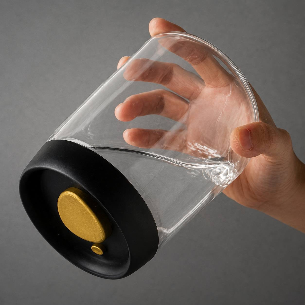 Hand holding a vacuum-sealed glass coffee jar sideways to demonstrate the strength of the air-tight lid.
