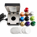 Compact electric sealing machine for various colored refillable coffee capsules with a set of foil lids on a white background.