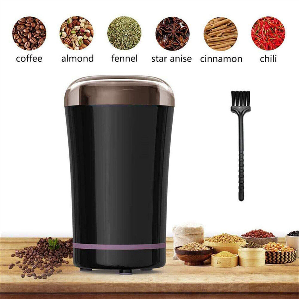 Black electric grinder surrounded by bowls of coffee beans, almonds, fennel, star anise, cinnamon, chili, and a cleaning brush.