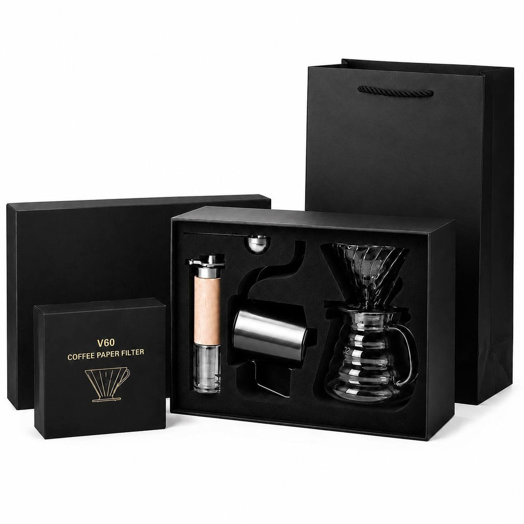 A complete coffee brewing kit including a box of filters, a dripper, a grinder, a kettle, and a gift bag on a white background.