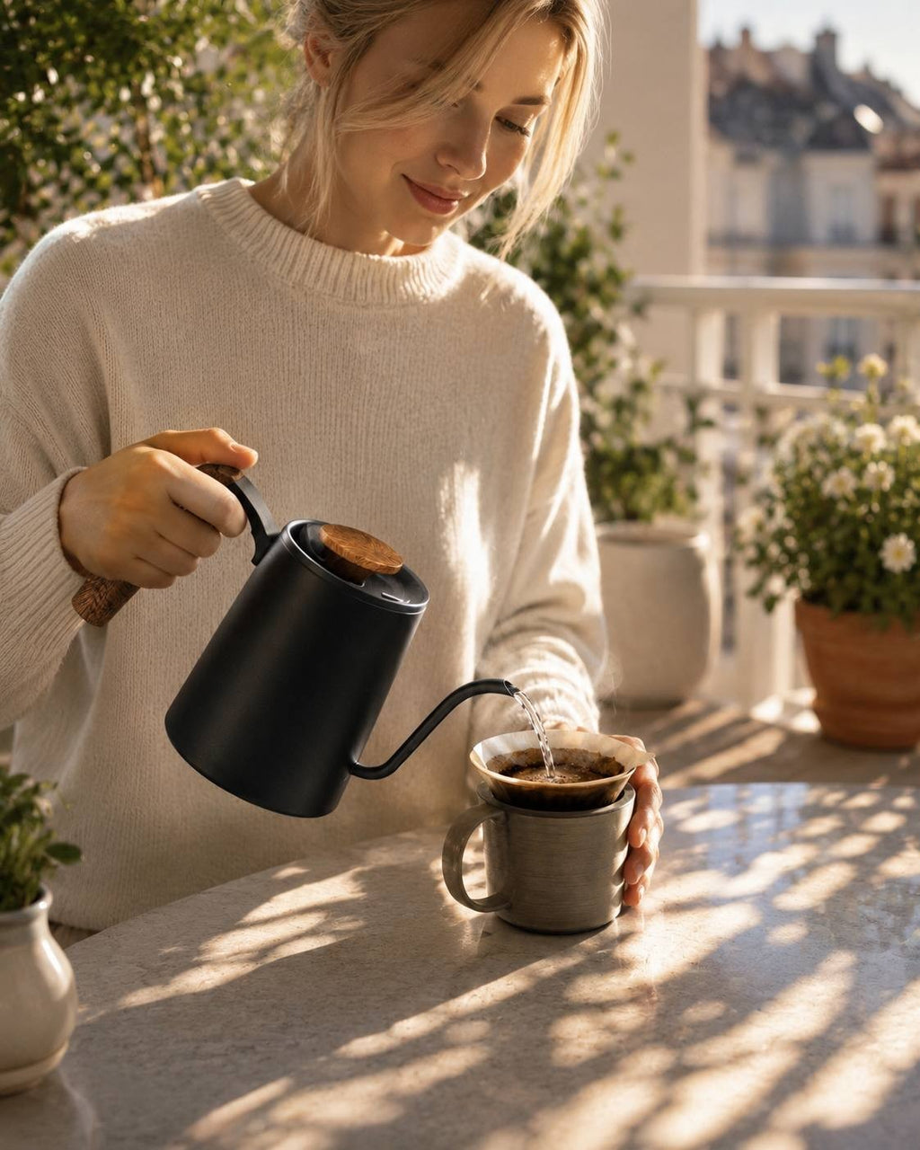 woman pouring water from a gooseneck kettle over a coffee dripper placed on a ceramic mug.