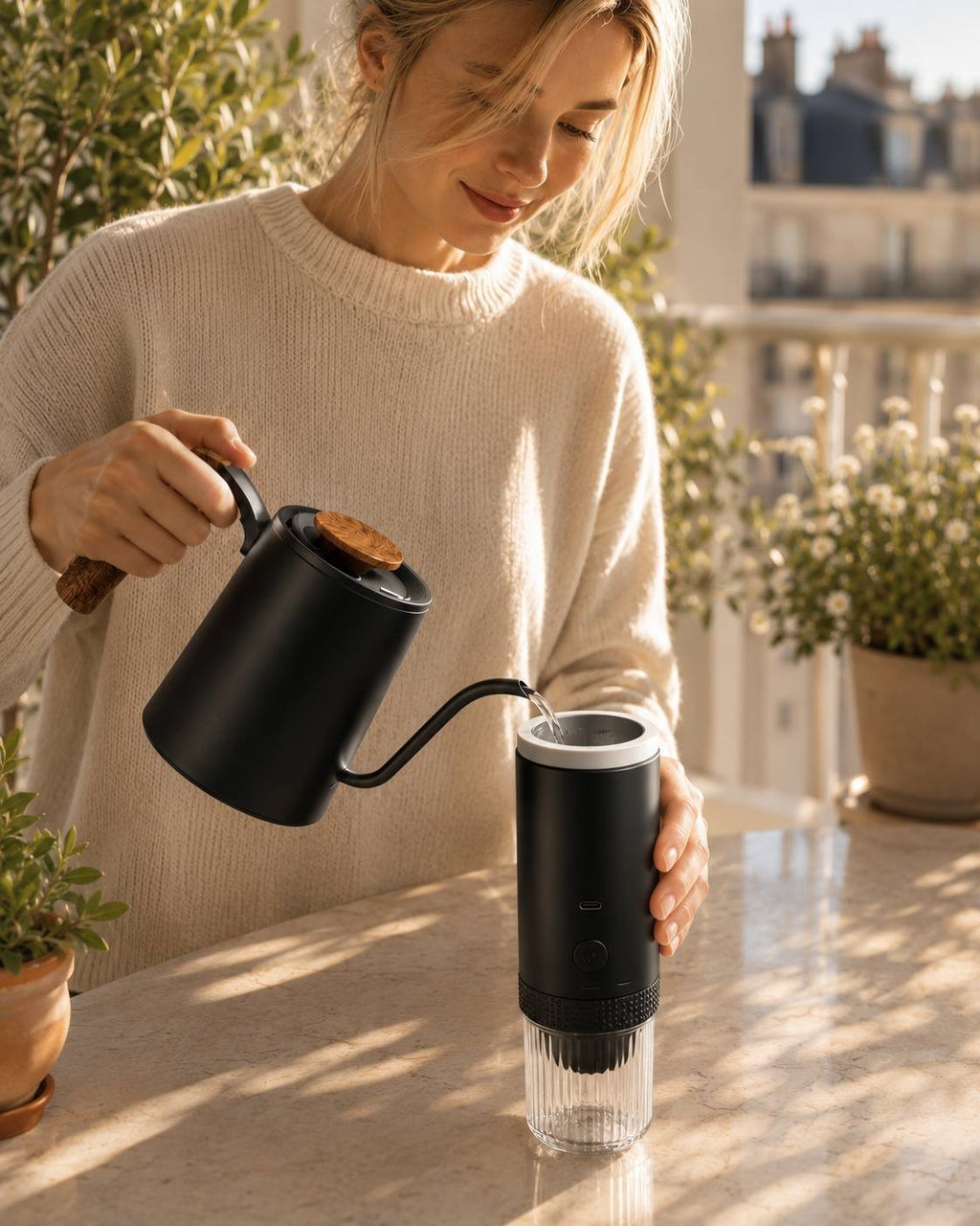 woman pouring hot water from a gooseneck kettle into a portable coffee maker.