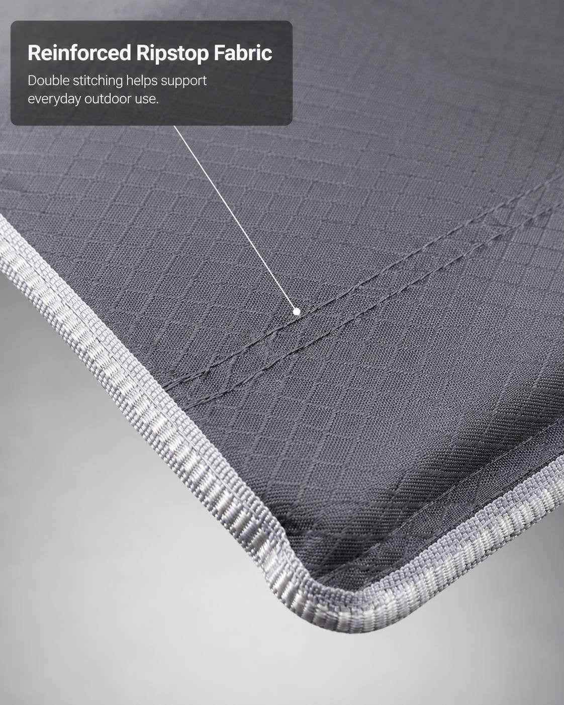 Close-up of grey ripstop fabric with double stitching along the edge of a camping cot.