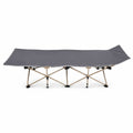Side view of a grey folding camping cot with an elevated headrest isolated on a white background.