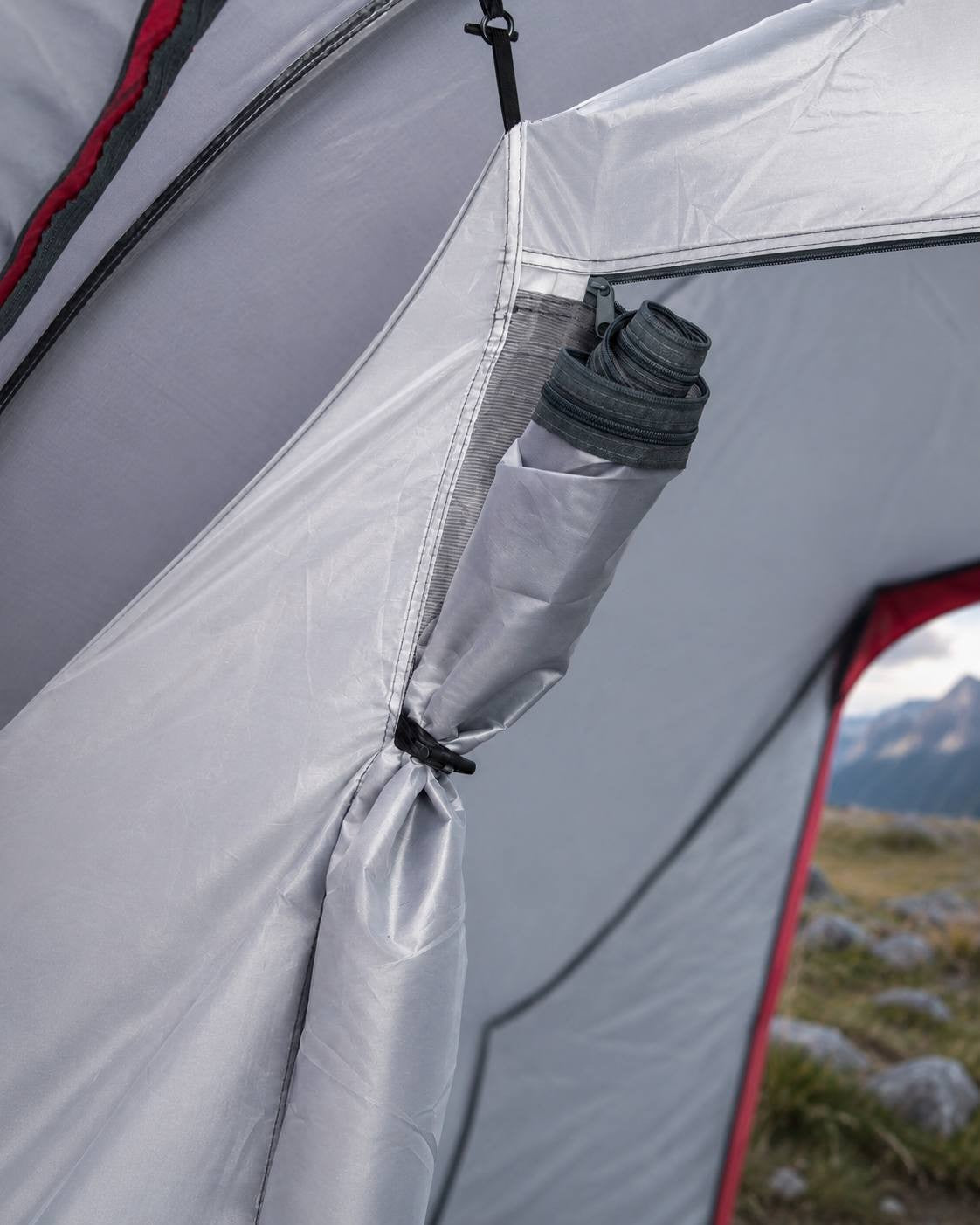 Close-up interior view of a camping tent showing the structural holder made of ABS plastic and the steel mesh component.