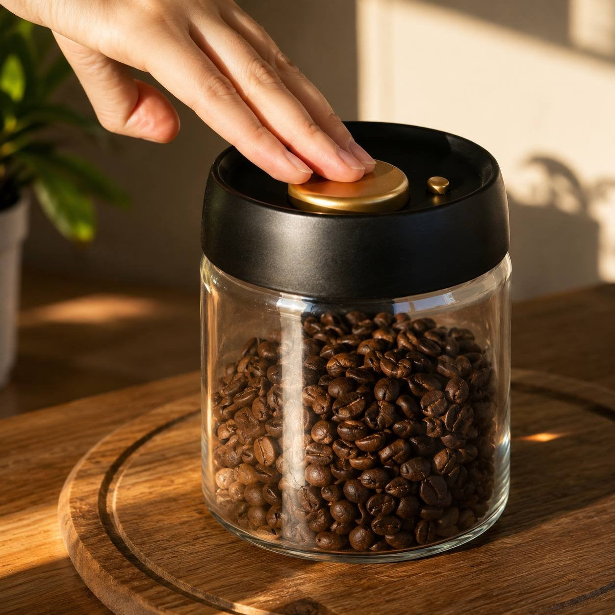 Close-up of a hand pressing the button on a vacuum-seal coffee canister lid on a wooden surface.
