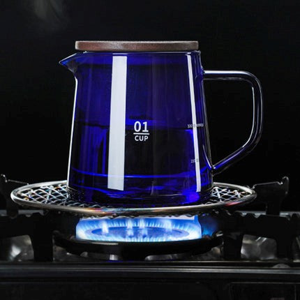 Blue glass teapot on a gas stove with visible flame