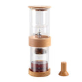 Clear glass coffee maker with wooden accents on a white background