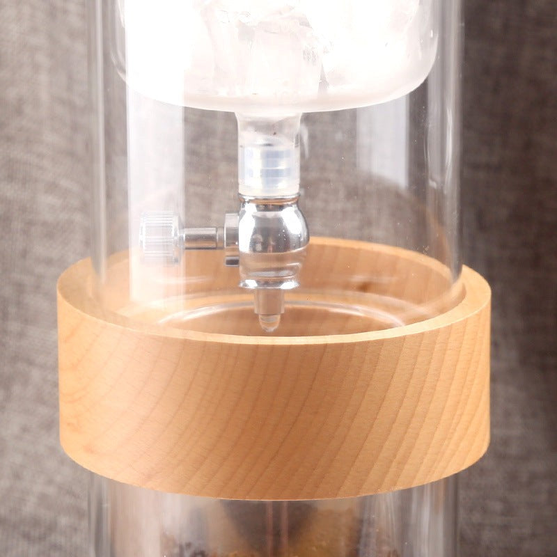 Clear glass lamp with wooden base on a neutral background