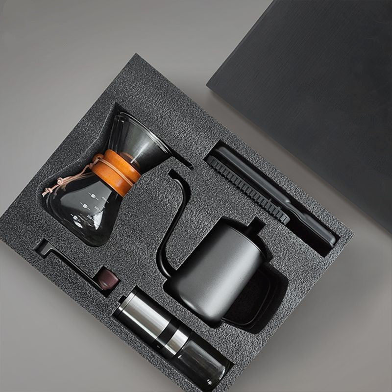 Coffee brewing kit with various components in a gray foam packaging on a gray background
