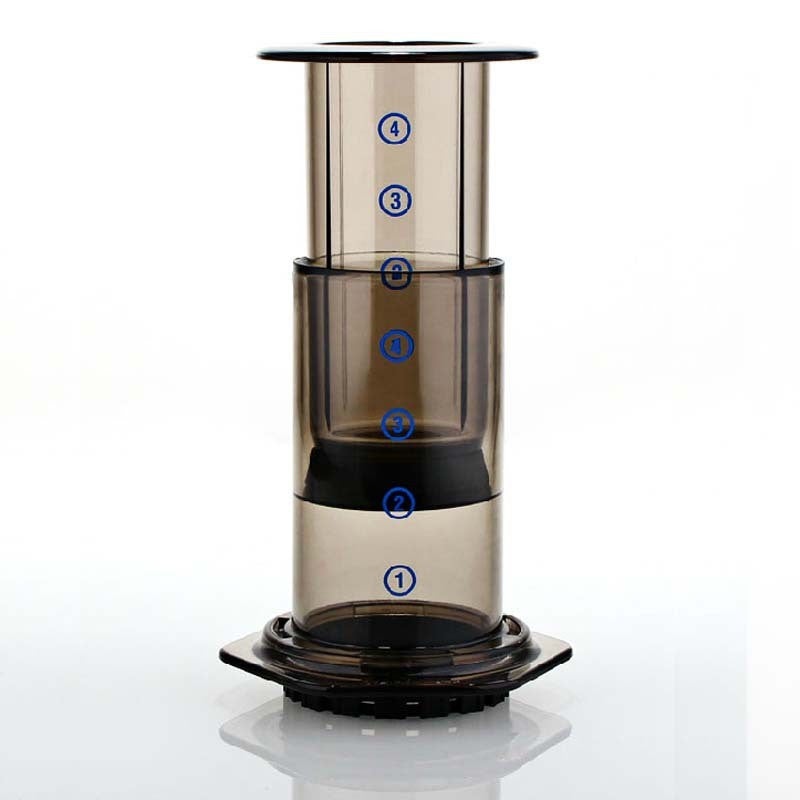Clear cylindrical coffee maker with black base on a white background