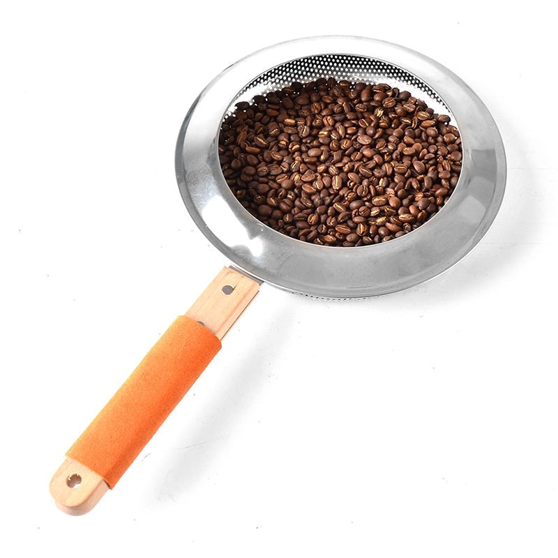 Metal strainer filled with coffee beans on a white background