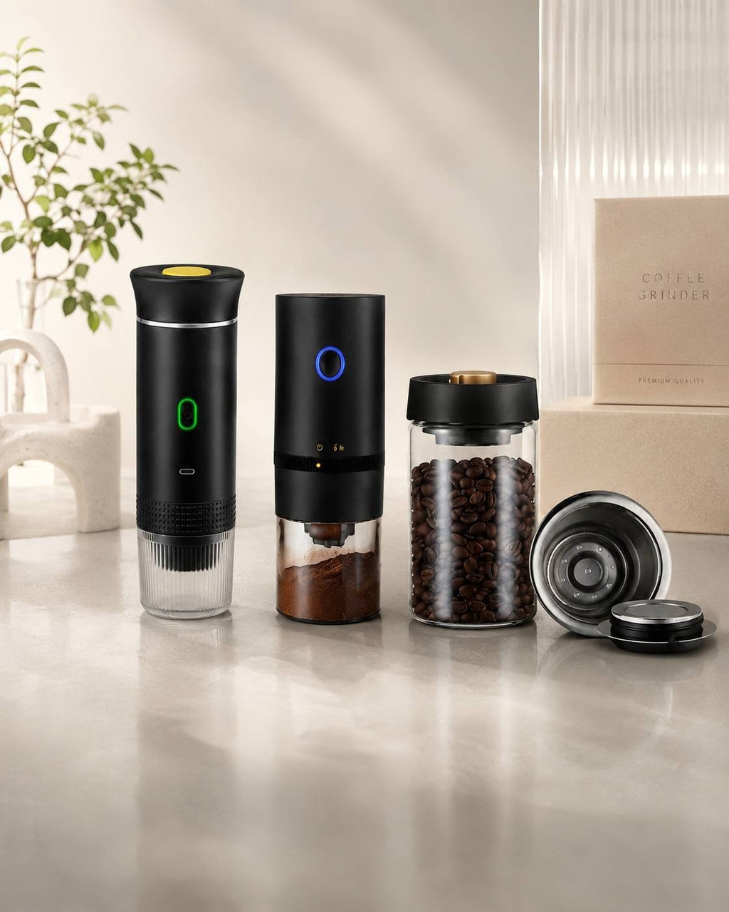 Portable coffee brewing set including a coffee maker, manual grinder, and glass bean container on a clean marble surface.