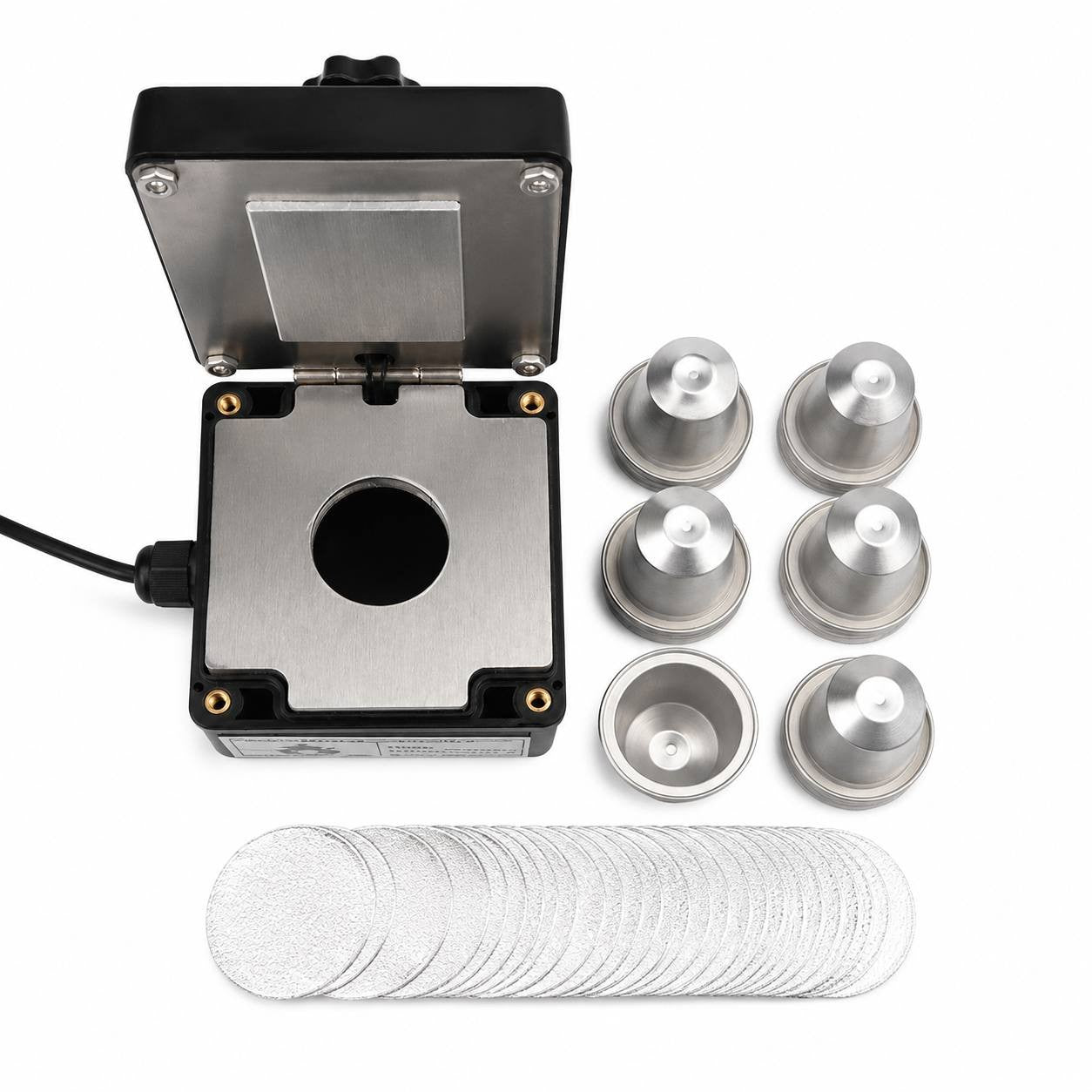 Portable coffee capsule sealing machine with a set of silver refillable capsules and aluminum foil lids.