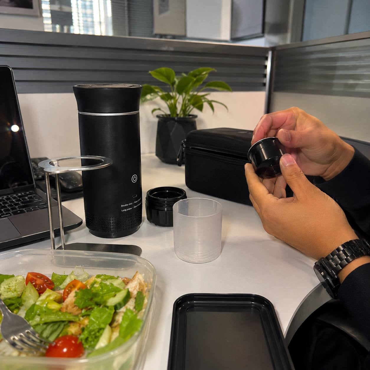 Preparing fresh coffee with a portable espresso maker during a lunch break at the office.