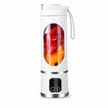 Studio product shot of a white portable cordless electric blender filled with fresh strawberries and mango chunks against a clean white background.