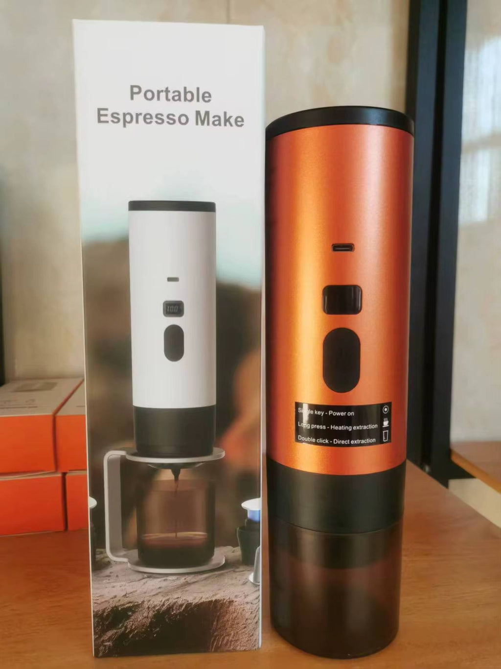 Compact bright orange travel espresso machine showcasing its handheld wireless body and power button