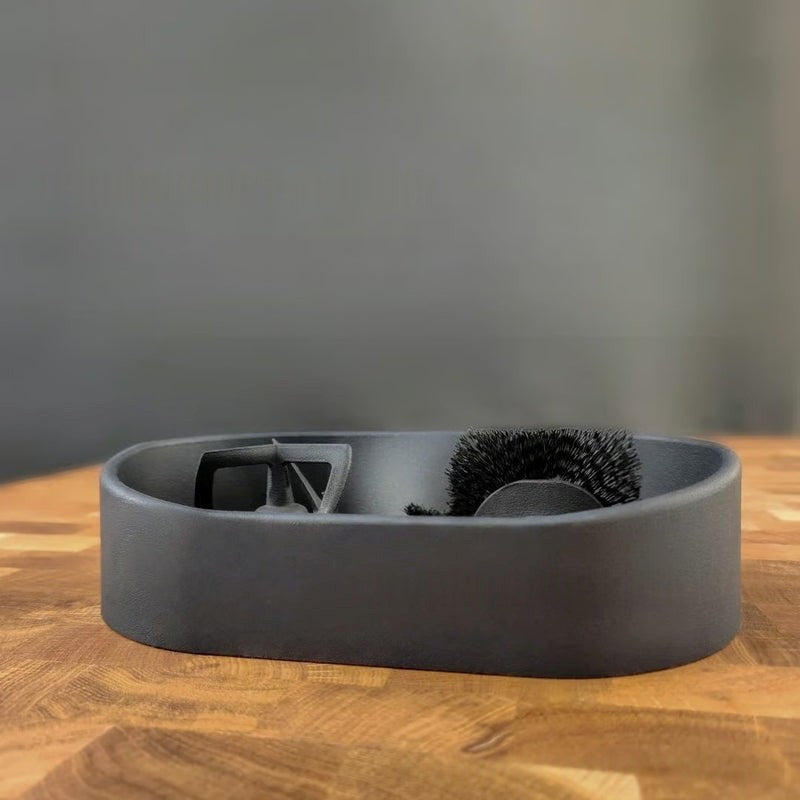 Gray grooming tray with brush and scissors on a wooden surface