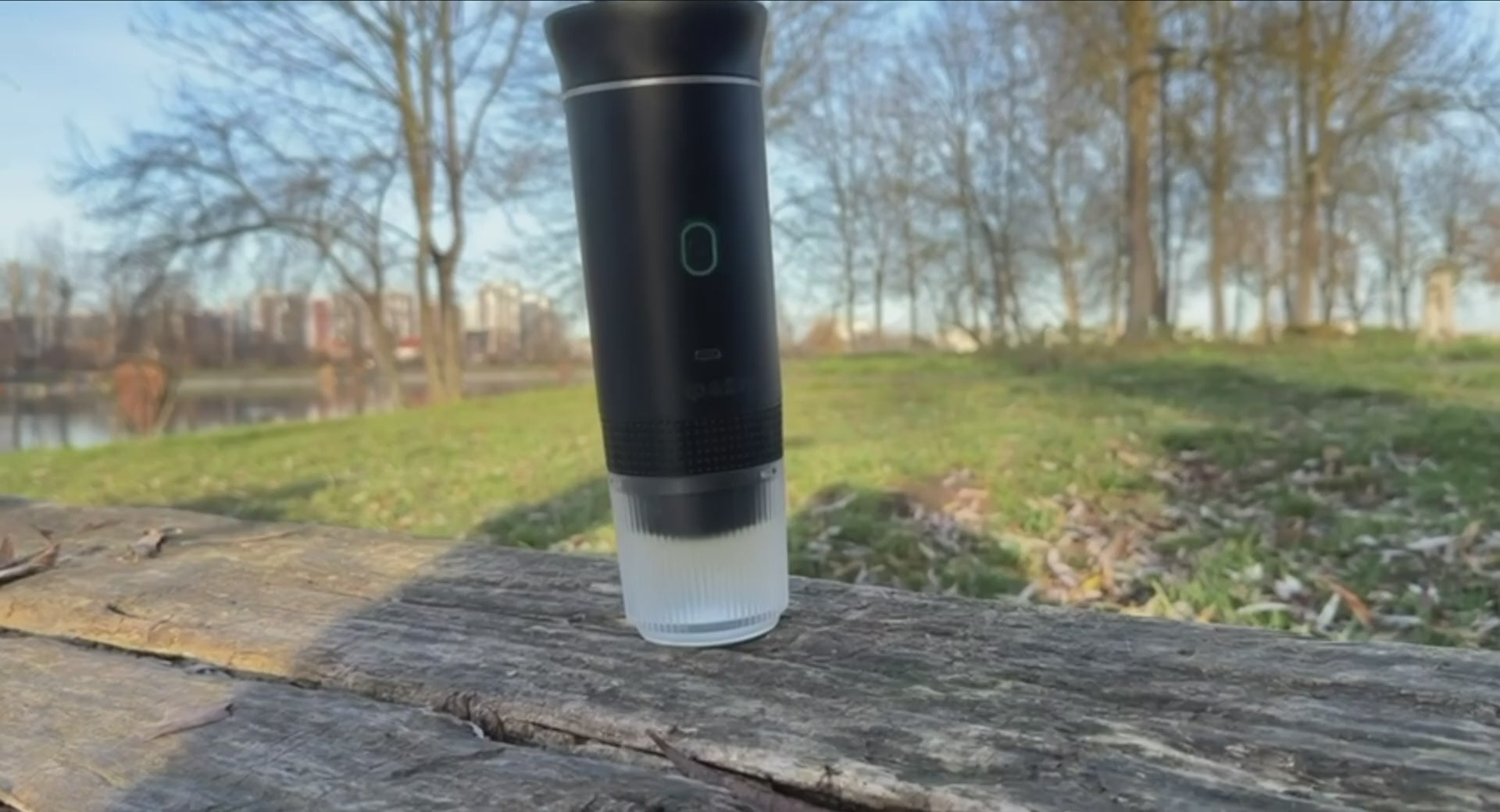Portable coffee maker outdoors in a park setting.
