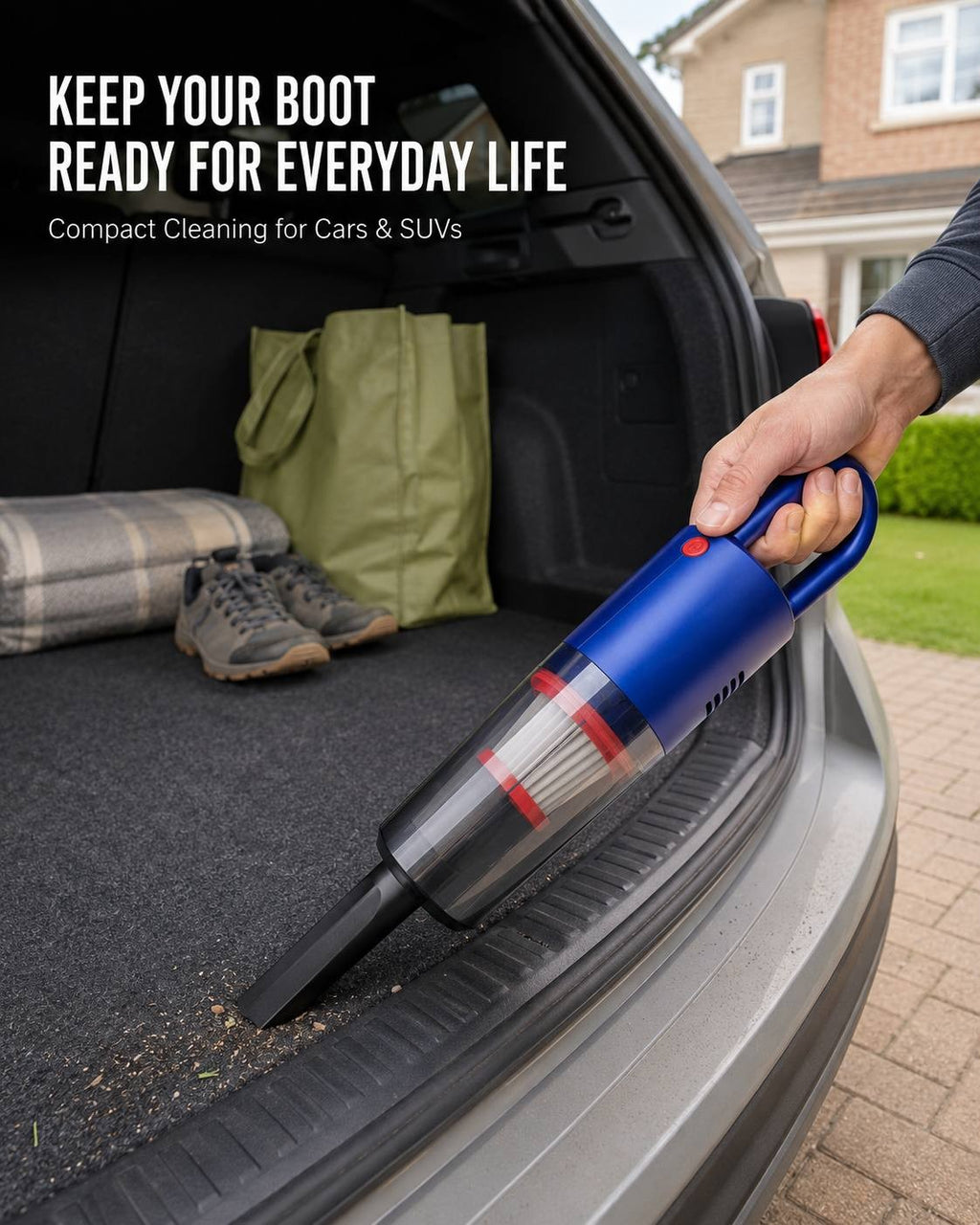 A person using a blue cordless handheld vacuum cleaner to clean the carpeted threshold of an SUV trunk, with camping gear and a shopping bag visible in the background.